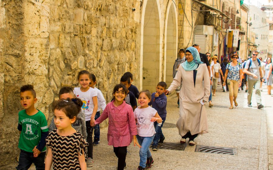 Niños caminando por una calle empedrada del casco histórico en Israel